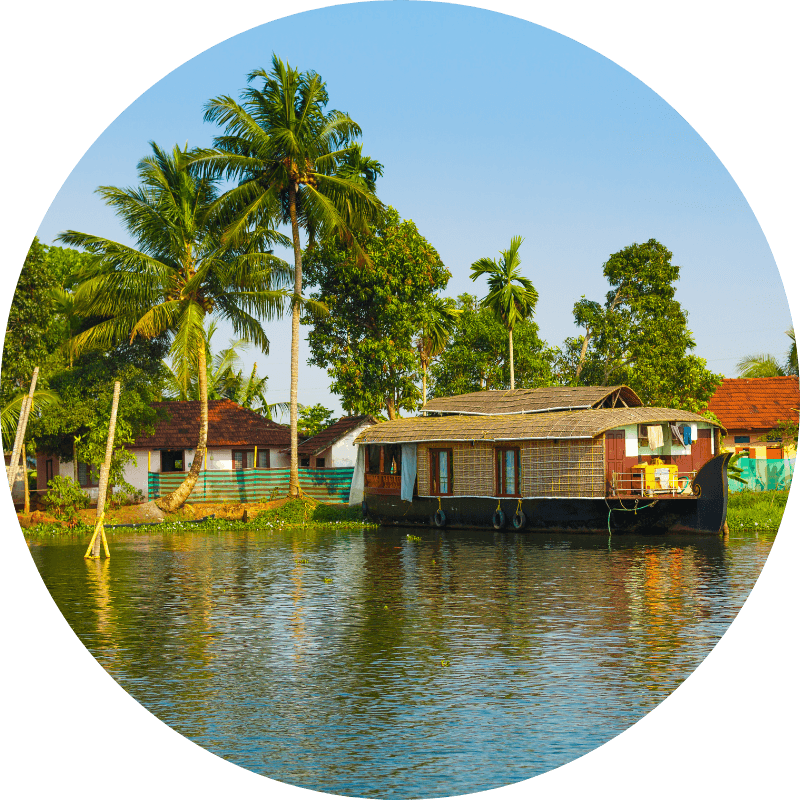 Maisons flottantes traditionnelles sur un cours d'eau avec palmiers et végétation tropicale, région du Kerala en Inde